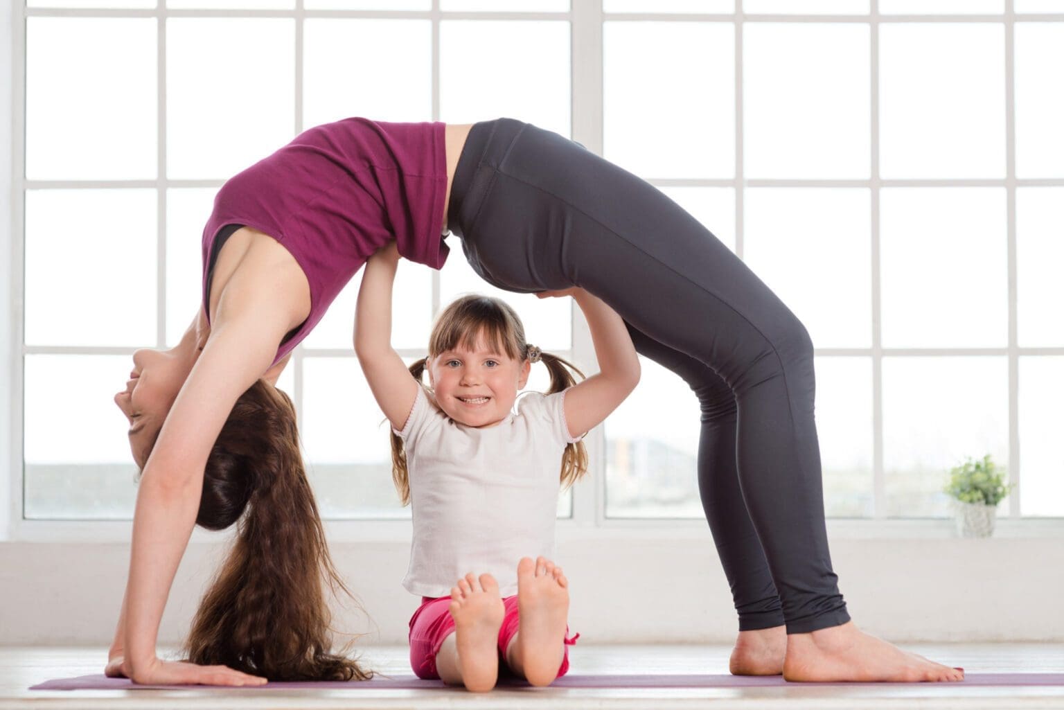 mom doing yoga with daughter