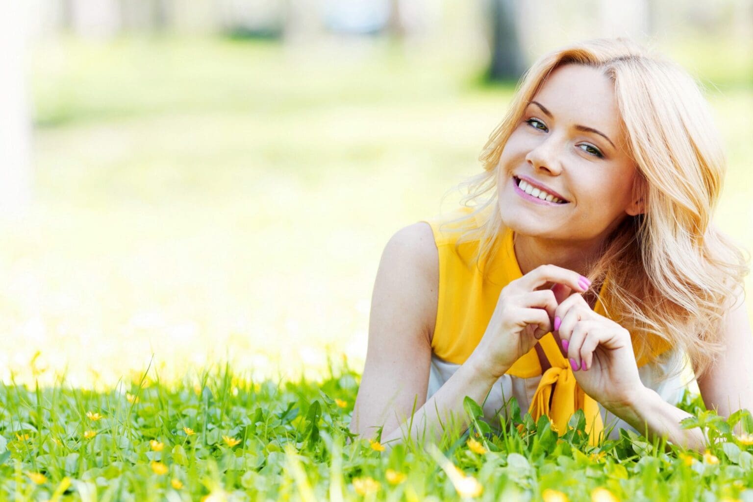 smiling woman lying on grass